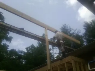 Carpenter setting a ridge beam over a new addition frame — Ice Dam Removal by Roofing Brothers in Travelers Rest