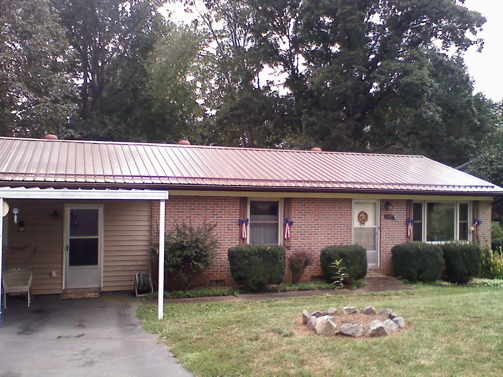 Bronze metal roof and carport on a brick ranch home — Roof Repair work by our crew in Travelers Rest